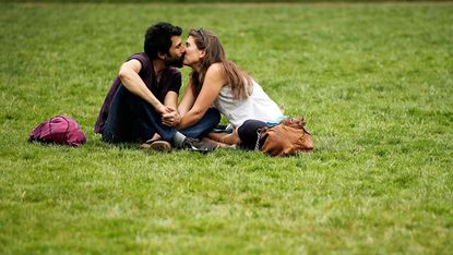 A couple kisses in a park