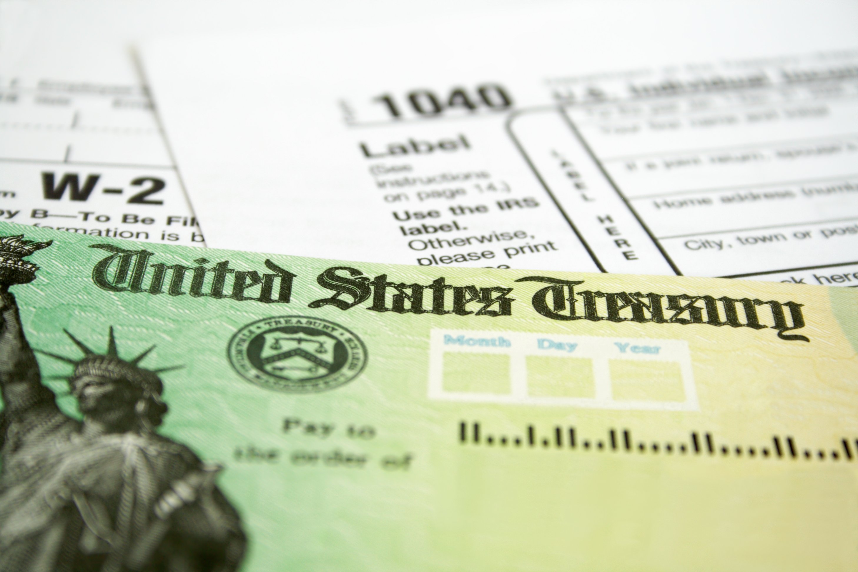 close up of tax refund check on top of Form 1040
