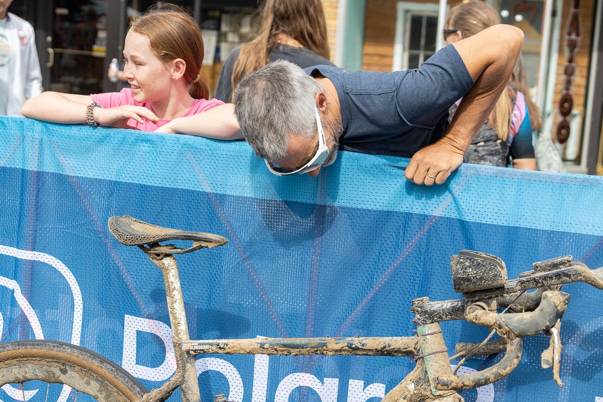 A spectator checks out Lauren De Crescenzo's Cannondale bike while she was being interviewed.