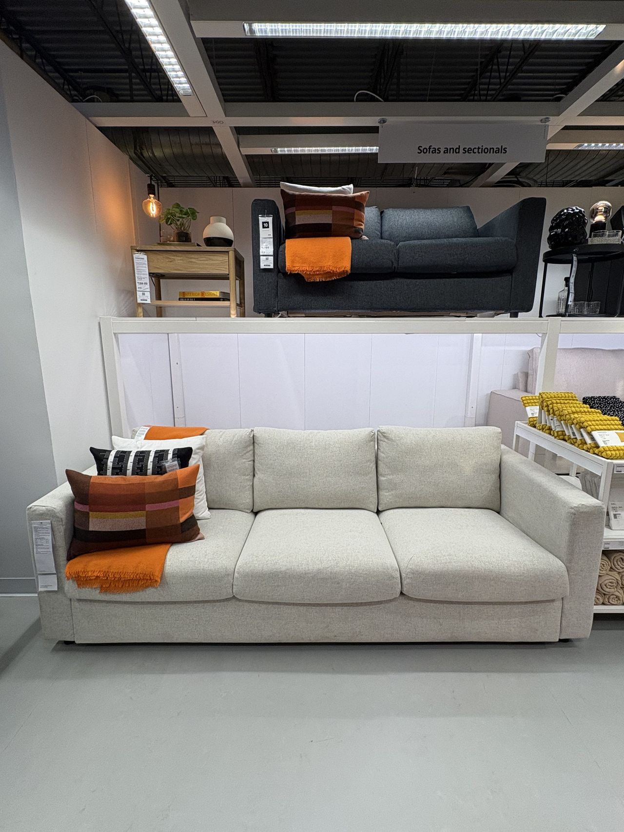 an offwhite sofa sits in an IKEA showroom.