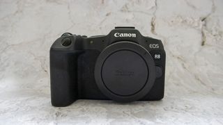 Canon EOS R8 camera on table with plain background
