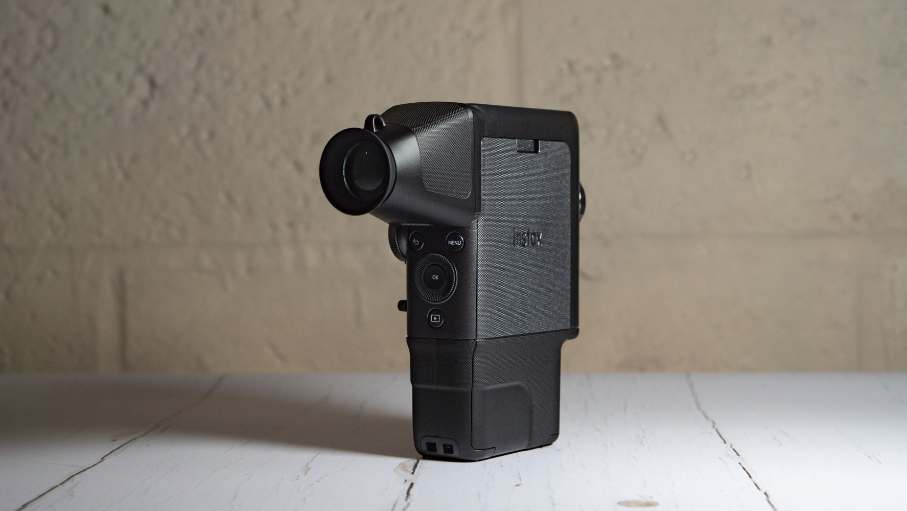 Fujifilm Instax Mini Evo Cinema on a white wooden surface