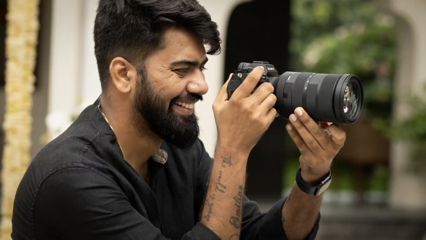 Close up of a smiling photographer using the SIGMA 28-105mm F2.8 DG DN | Art lens outdoors