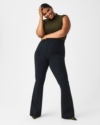 Model wears The Perfect Pant in black and olive green mockneck top.