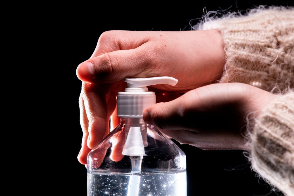 A woman uses hand sanitizer.