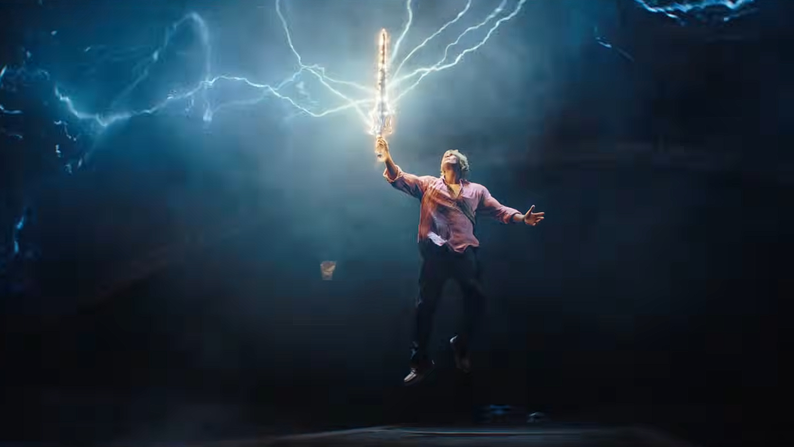 A man holding a sword as lightning strikes the blade in a sci-fi fantasy film