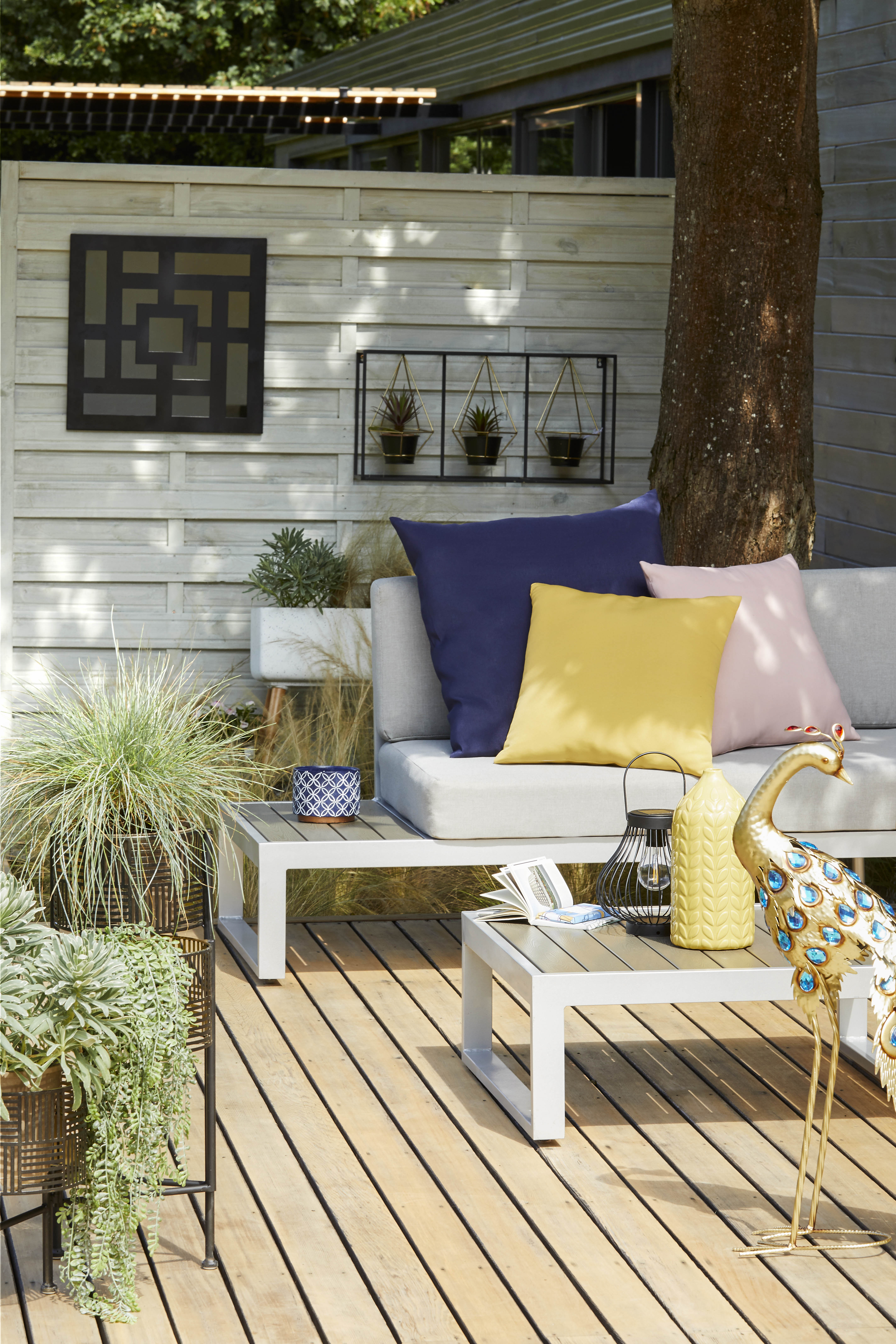 Outdoor sofa on partially covered patio with bright soft furnishings and minimal planting