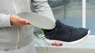 Man removing insole from running shoe
