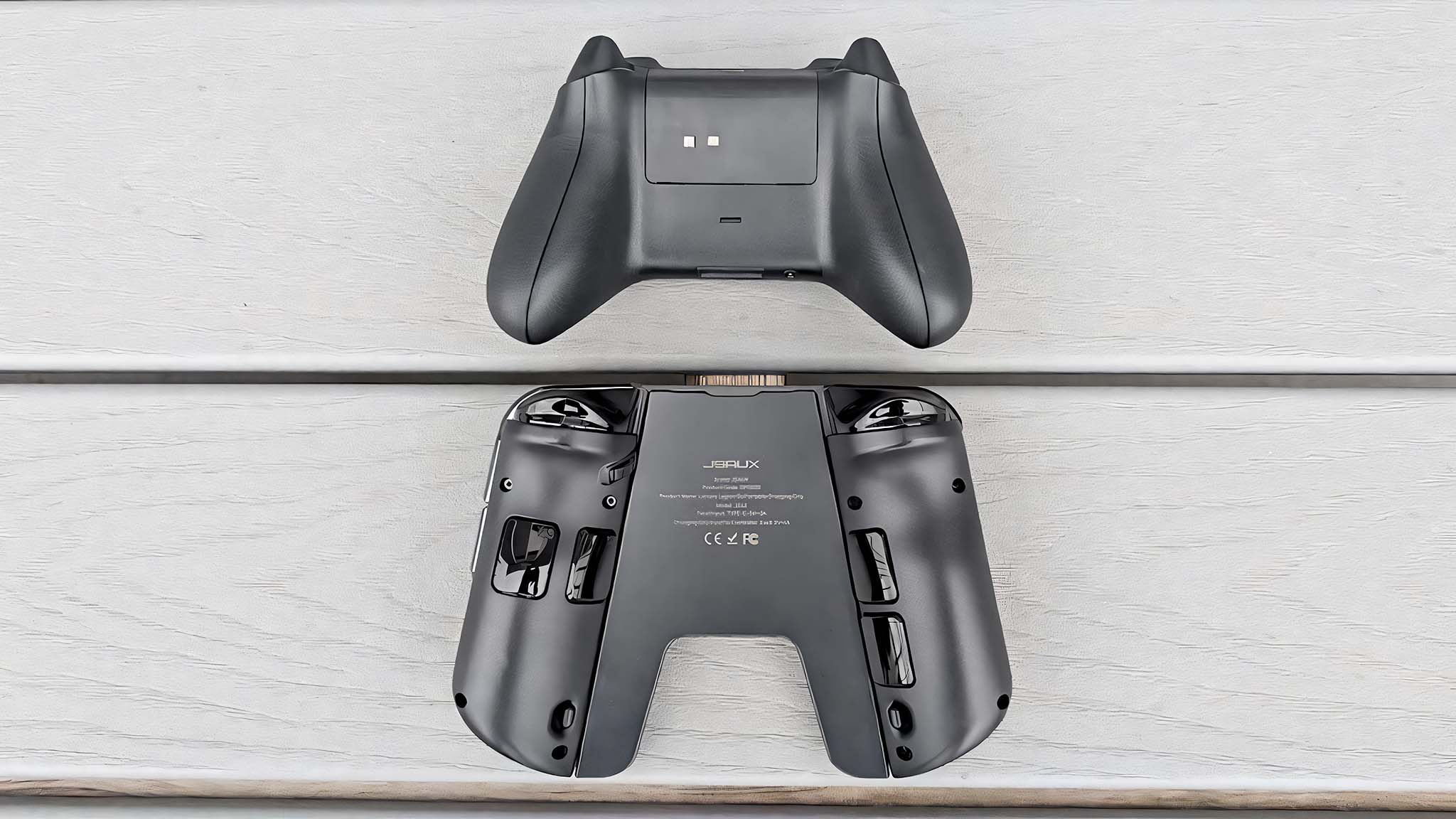 The backsides of a JSAUX Grip Connector for Legion Go Controller and an Xbox controller.