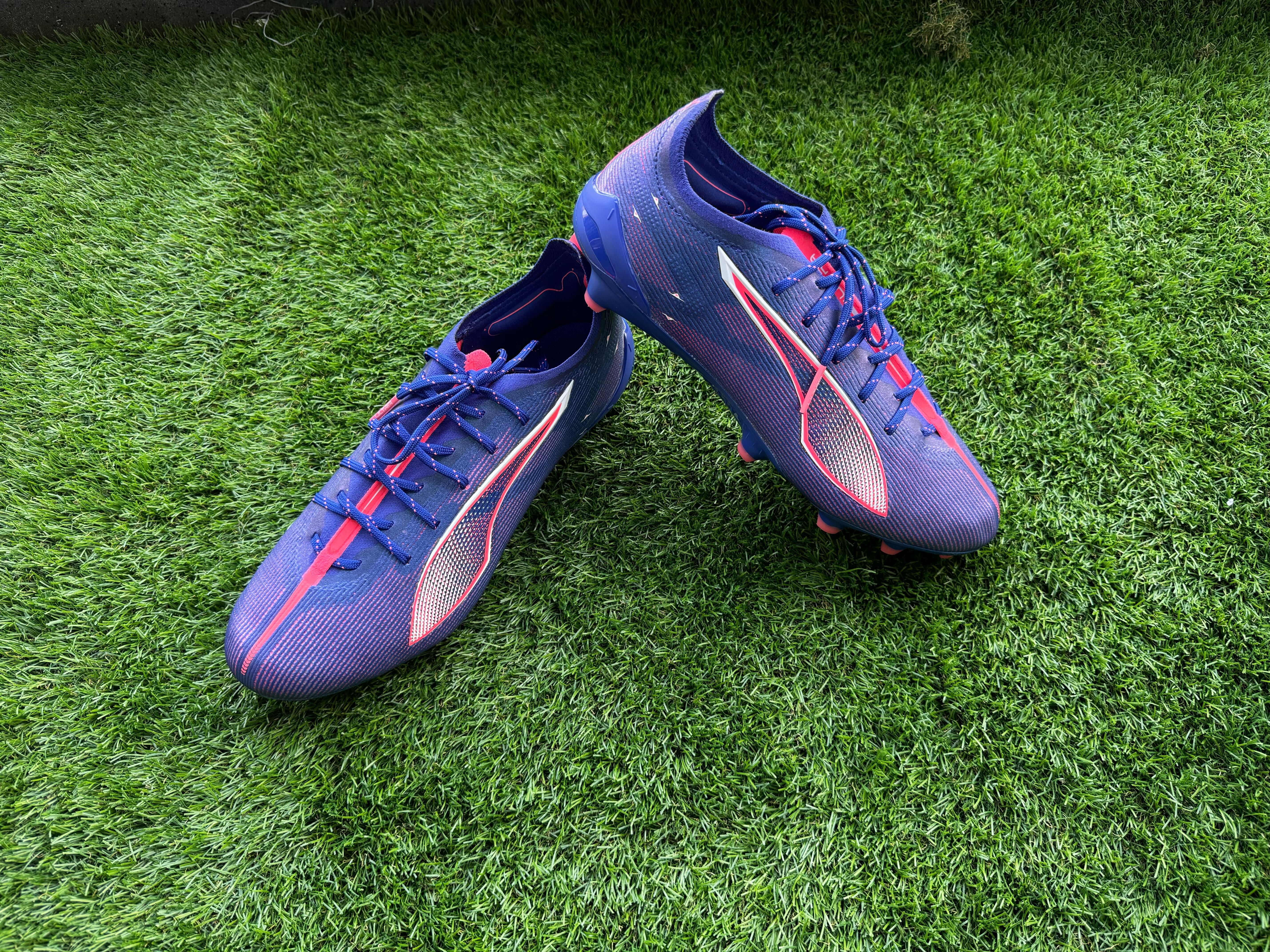 Puma Ultra 5 Ultimate football boots placed on a piece of astro turf for reviewing