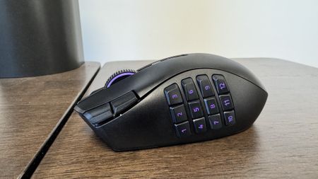 The Razer Naga V3 Pro on a wooden table from the left hand side, showing the 12 button faceplate