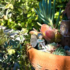fairy garden container with fairy and plants