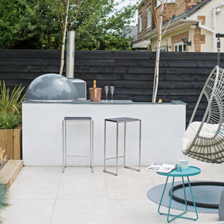 outdoor kitchen made from concrete with pizza oven and egg chair