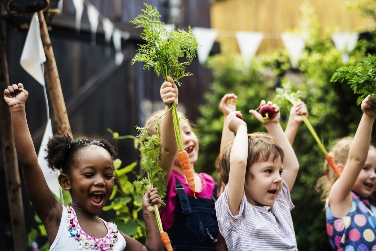 Kids Holding Vegetables in their Agrihood Community