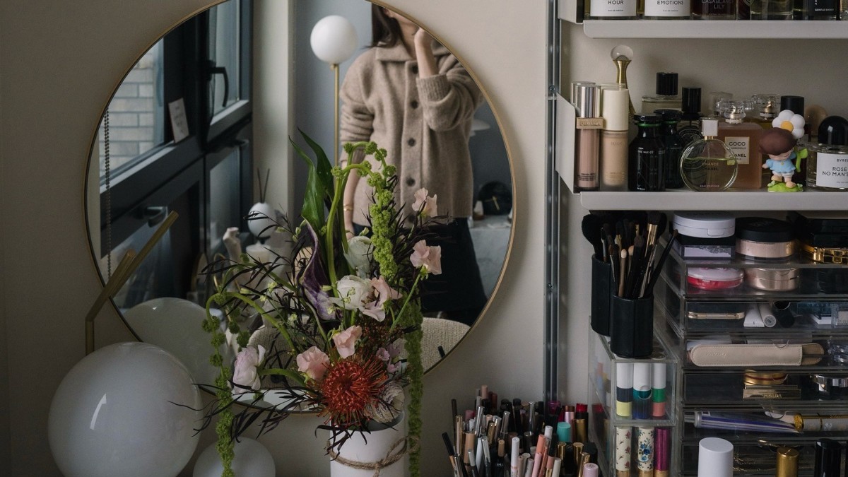 Photo of Erica Choi taking a mirror selfie at her makeup vanity