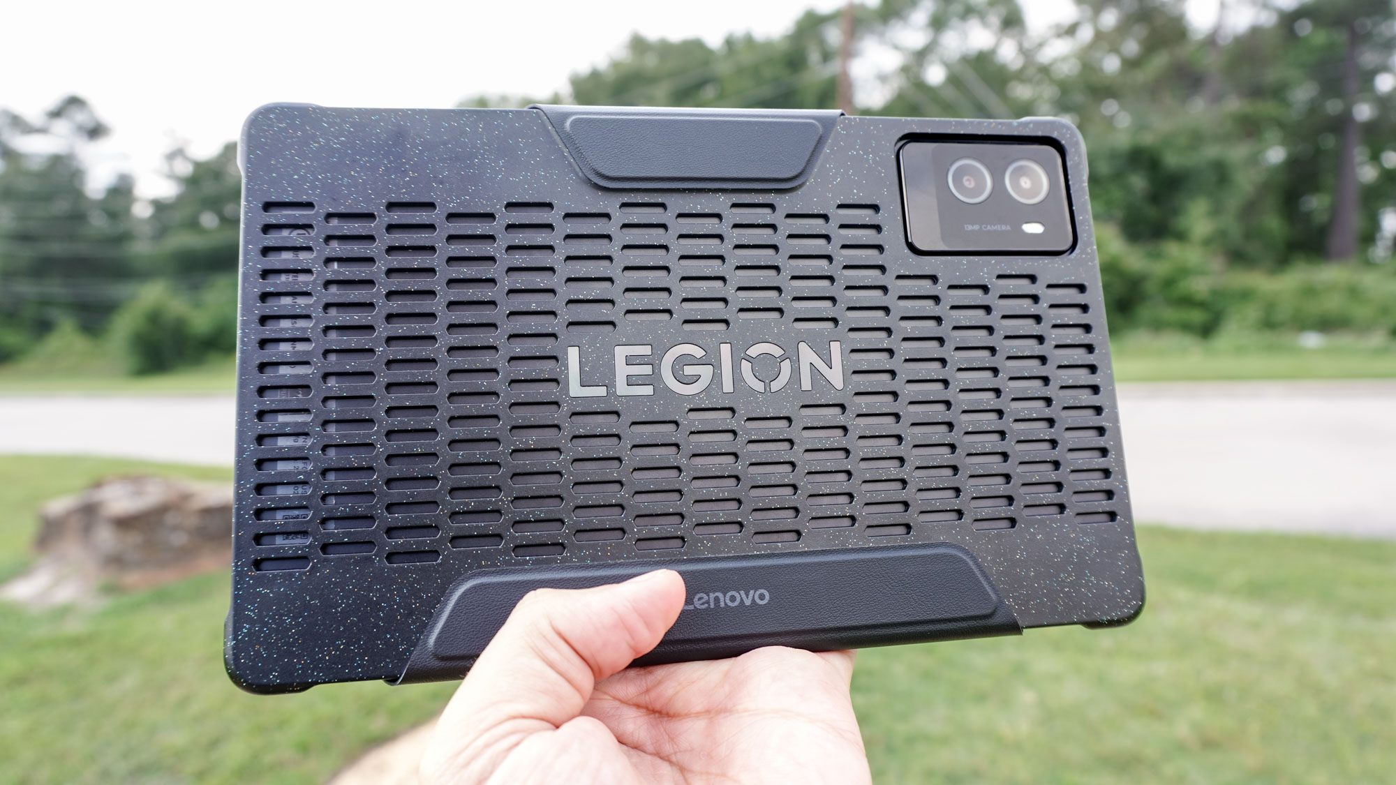 A person holding the Lenovo Legion Tab Gen 3 in landscape mode outside