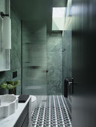 green stone tiled bathroom with walk in shower