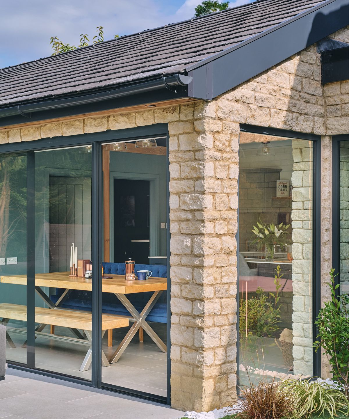 Close in shot of a stone built extension with pitched roof and aluminium framed sliding doors