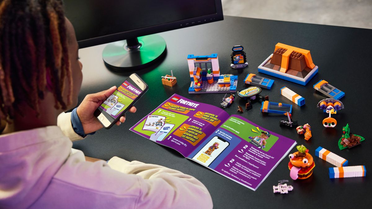 A person constructing the Lego Durrr Burger Restaurant set using instructions