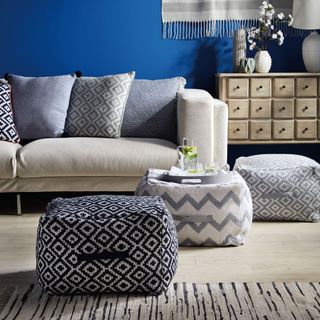 living room with blue wall and sofa set with multi design cushions