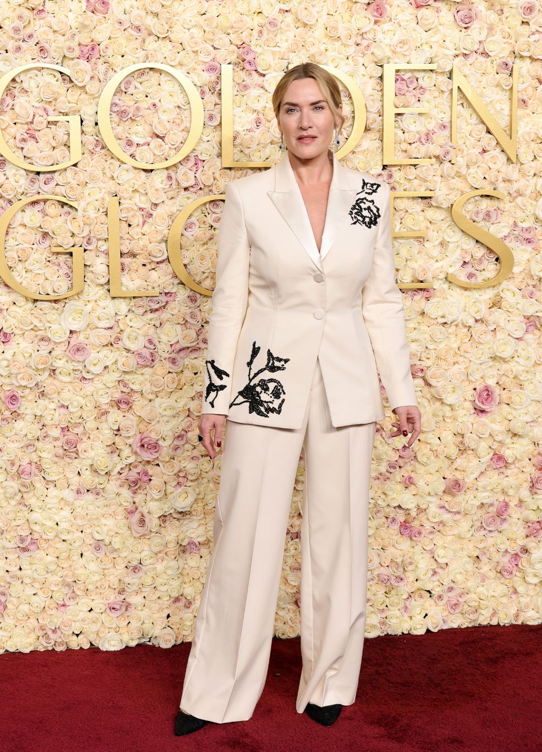 Kate Winslet in a cream suit with black patterns