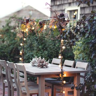outdoor dining table with string lights across the top