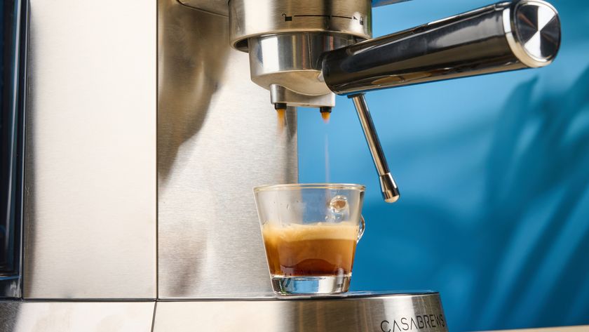 the casabrews cm5418 espresso machine in silver showing its steam wand and water tank and accessories