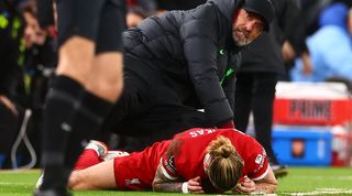 Liverpool's Kostas Tsimikas is hurt after colliding with manager Jurgen Klopp in the Reds' Premier League game against Arsenal in December 2023.