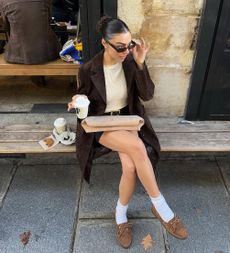 A picture of a woman sitting outside of a coffee shop.