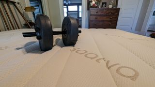 Saatva Memory Foam Hybrid mattress review, testing pressure relief with a dumbbell