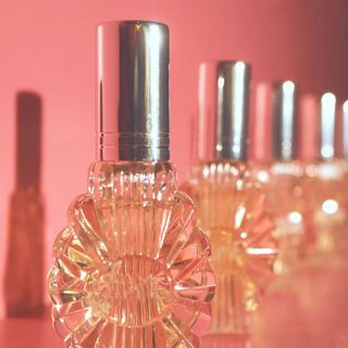 Bottles of perfume on a pink background