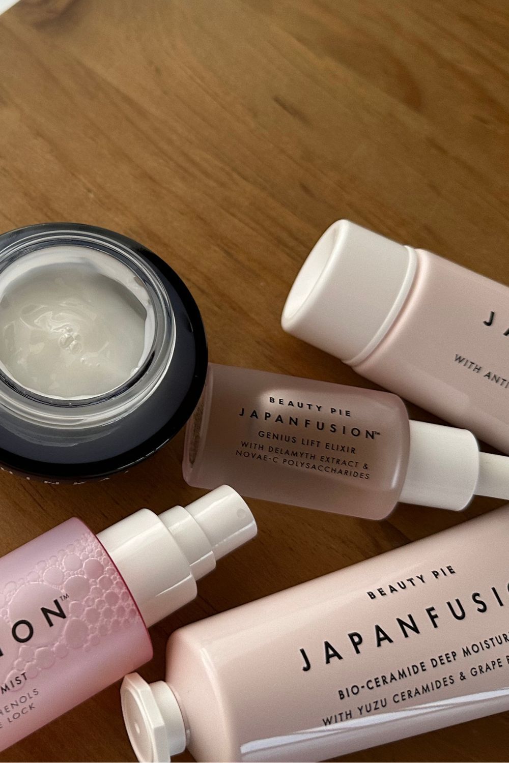 Beauty Pie Japanfusion skincare products laid on a wooden table