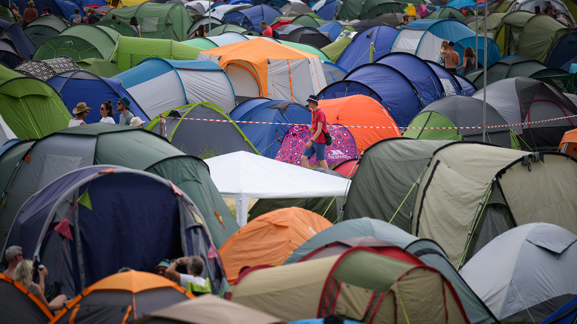 GLASTONBURY, ENGLAND - JUNE 23: A festival-goer walks between the tents in one of the camping areas during day two of Glastonbury Festival at Worthy Farm, Pilton on June 23, 2022 in Glastonbury, England. (Photo by Leon Neal/Getty Images)