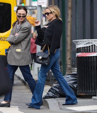 Reese Witherspoon wears a Celine tweed jacket with a black Celine Victoire bag and flare jeans.