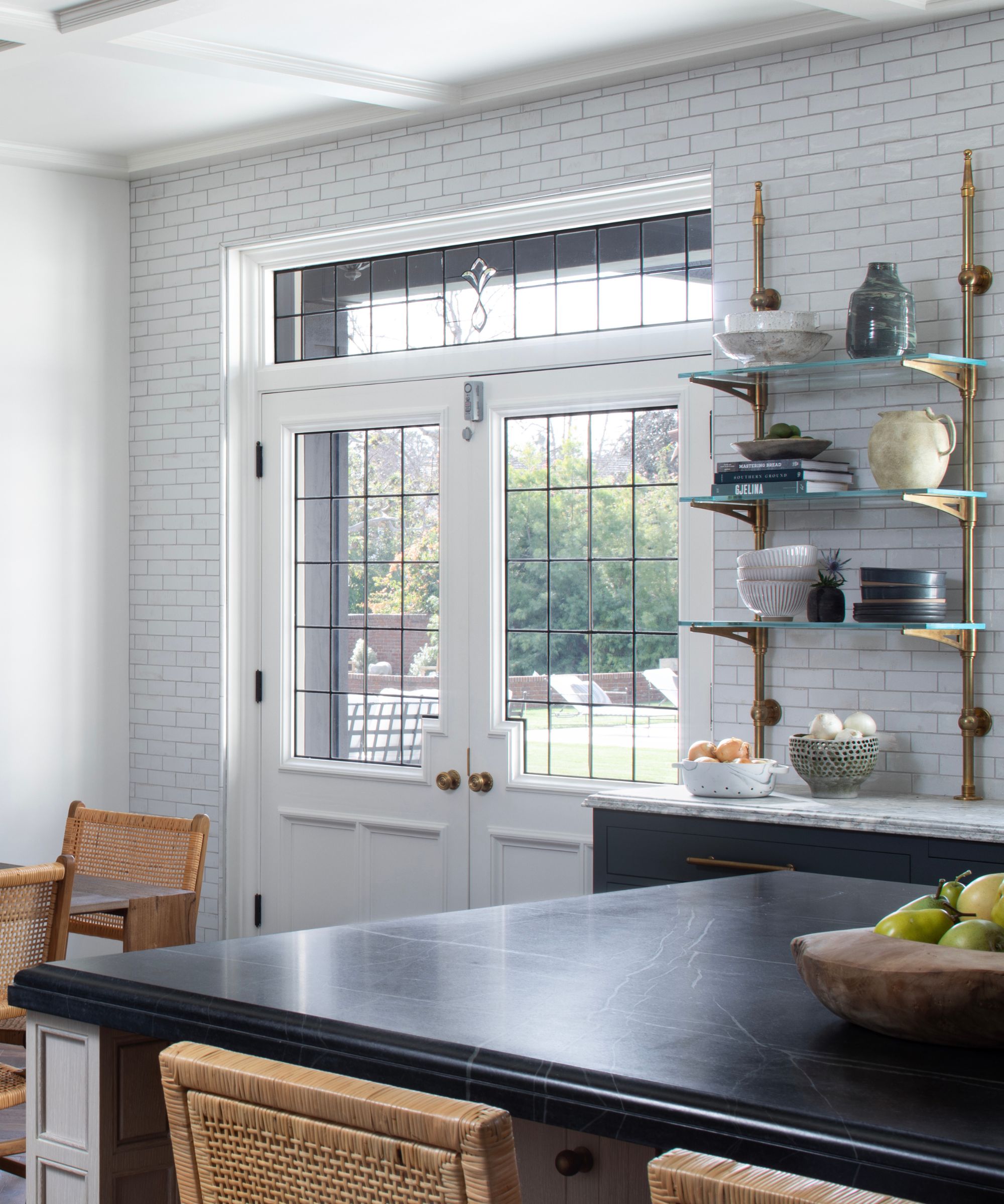 kitchen with dark countertop and white subway tiles all the way to the ceiling