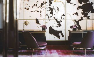 Purple armchairs in front of large wall art