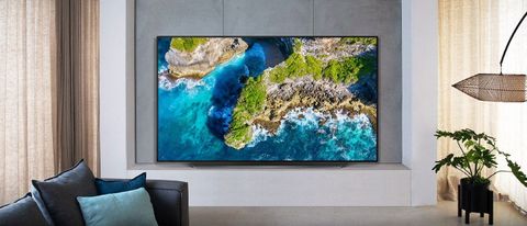 The LG CX OLED TV showing a piece of coastline, at back of stylish living room