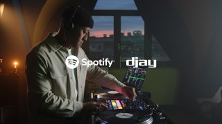 A man at DJ decks in a promo photo for Spotify integration with djay