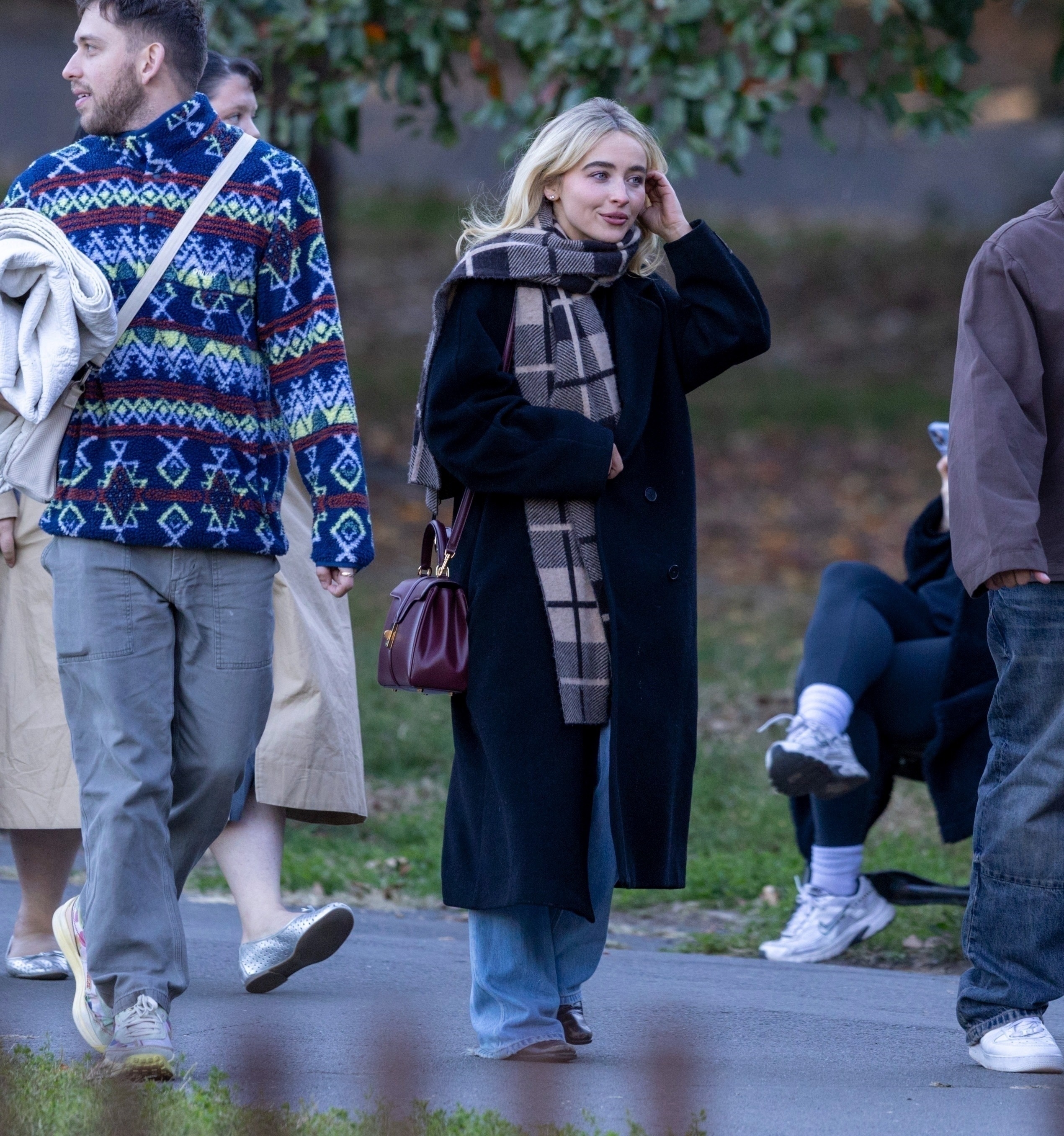 Sabrina Carpenter was spotted in New York's Brooklyn wearing a black coat, a plaid scarf, and a burgundy Celine bag