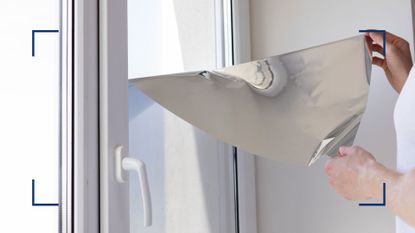 picture of person putting foil film on windows