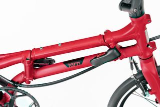 A close up of the red Tern BYB P10 twin top tube and folding hinge system against a white background