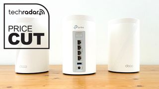 Three TP-Link Deco BE65 devices on a wooden surface and a price cut badge