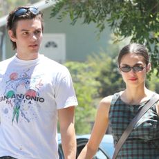 Olivia Rodrigo wearing a plaid dress walking with boyfriend Louis Partridge