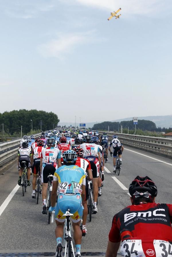 The riders watch a fire fighting plane above the race