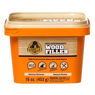 An orange tub of wood filler