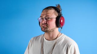 the fiio ft13 wired headphones with wood cups and copper cable photographed against a blue background