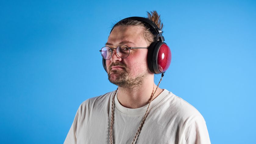 the fiio ft13 wired headphones with wood cups and copper cable photographed against a blue background