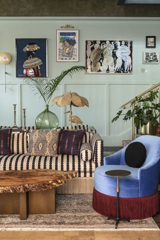 eclectic living room with wood panelling on the walls and fringed sofa and armchair