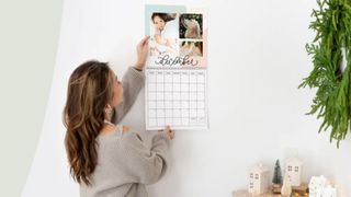 Woman placing a photo calendar on the wall