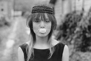 Photo of girl in garden blowing bubblegum